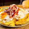 Huevos rotos de jamón ibérico y cama de trufa 